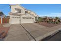 Two-story stucco home features a three-car garage, desert landscaping, and tile roof at 20709 N 56Th Dr, Glendale, AZ 85308