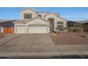 Gorgeous stucco home with large arched window, three-car garage, and low maintenance desert landscaping at 20709 N 56Th Dr, Glendale, AZ 85308