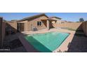 Backyard featuring a pool, desert landscaping, a putting green, and a covered patio at 22583 W Lasso Ln, Buckeye, AZ 85326