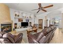 Comfortable living room with fireplace, built-in shelves, and elegant tile flooring at 2855 N Silver Spur Dr, Wickenburg, AZ 85390