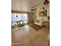 Inviting living room with tile floors, ceiling fan, a white sofa and many plants at 4845 W Marlette Ave, Glendale, AZ 85301
