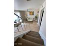 Open-concept view from the stairs shows the bright living room with tile floors and lots of plants at 4845 W Marlette Ave, Glendale, AZ 85301