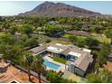 Expansive estate showcasing a large pool, sports court, and a mountain backdrop, perfect for luxurious outdoor living at 6301 E Exeter Blvd, Scottsdale, AZ 85251