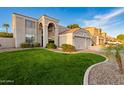 Attractive two-story home with a lush green lawn, stone accents, and a double garage enhancing its curb appeal at 9426 E Los Lagos Vista Ave, Mesa, AZ 85209