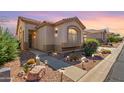 Charming single-story home with low-maintenance landscaping, walkway lighting, and a warm, inviting exterior at 9537 E Flint Dr, Gold Canyon, AZ 85118