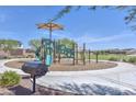 Community playground with slides and play equipment sitting on a bed of mulch under a sunshade at 17166 W Oberlin Way, Surprise, AZ 85387