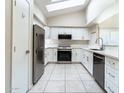 Modern kitchen featuring white cabinets, stainless steel appliances, tile backsplash, and a skylight for natural light at 1723 E Behrend Dr, Phoenix, AZ 85024