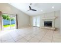 Spacious living room featuring a fireplace, neutral paint, tile flooring, and glass doors to the backyard at 1723 E Behrend Dr, Phoenix, AZ 85024