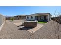 Backyard with a circular patio with ample seating, artificial turf, and desert landscaping at 17878 W Amber Ridge Way, Goodyear, AZ 85338