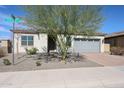 Charming single-story home with desert landscaping, a brick driveway, and a gray garage door at 17878 W Amber Ridge Way, Goodyear, AZ 85338