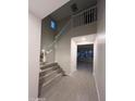 Spacious hallway with staircase featuring neutral paint and wood-style tile flooring at 18243 W Larkspur Dr, Goodyear, AZ 85338