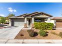 Inviting single-story home featuring a stone-accented facade, well-kept lawn, and attached garage at 19982 W Glenrosa Ave, Litchfield Park, AZ 85340