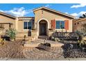 Inviting front exterior with desert landscaping, brick pathway, and charming decorative iron door at 20391 N Sunrise Ln, Maricopa, AZ 85138