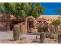 Close up of a home featuring a arched entryway and native desert landscaping at 2070 W Bromm Ln, Wickenburg, AZ 85390