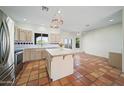 Bright kitchen with an island, stainless steel appliances and Saltillo tile flooring at 2070 W Bromm Ln, Wickenburg, AZ 85390