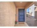 Covered front porch featuring a secure door, a welcome sign and neutral decor for a warm entry at 214 N 222Nd Dr, Buckeye, AZ 85326