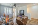 Cozy living room featuring wood floors, ceiling fan, and a modern fireplace at 2673 S Balsam Dr, Gilbert, AZ 85295