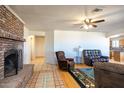 Cozy living room with a brick fireplace, ceiling fan and views into the kitchen at 27141 E Javelina Dr, Florence, AZ 85132