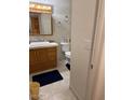 Well-lit bathroom with a single sink vanity, toilet, and tile flooring at 3828 W Port Au Prince Ln, Phoenix, AZ 85053