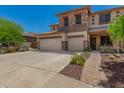 A two-story home showcasing a well-manicured yard and a stone-detailed facade, complemented by a blue sky at 4245 S 247Th Dr, Buckeye, AZ 85326