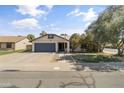 Inviting single-story home featuring a well-manicured front yard and a two-car garage at 45 S Rita Ln, Chandler, AZ 85226