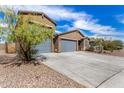 Charming single-story home featuring a gray garage door, desert landscaping, and a concrete driveway at 4642 W Suncup Dr, San Tan Valley, AZ 85144