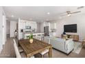 Open-concept living room features modern decor, seamlessly connecting the dining area and stylish kitchen at 4642 W Suncup Dr, San Tan Valley, AZ 85144