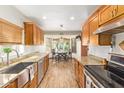 Galley kitchen featuring wood cabinets, granite counters, stainless steel appliances, and eat-in breakfast nook at 6208 W Willow Ave, Glendale, AZ 85304