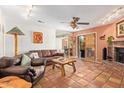 Cozy living room featuring Saltillo tile floors, a brick fireplace, leather furniture and rustic decor at 6208 W Willow Ave, Glendale, AZ 85304