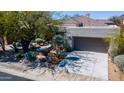 View of charming desert home featuring barrel cactus, desert landscaping, and an attached two-car garage at 7016 E Stone Raven Trl, Scottsdale, AZ 85266