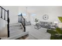 Living area with stairs, dining set, and grey sofa at 7270 W Tina Ln, Glendale, AZ 85310