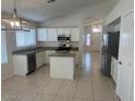 Well-lit kitchen with a stainless steel dishwasher, granite counters, and a modern light fixture at 7728 W Via Montoya Dr, Peoria, AZ 85383