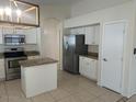 Well-lit kitchen featuring a stainless steel refrigerator and modern appliances at 7728 W Via Montoya Dr, Peoria, AZ 85383