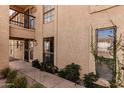 Charming condo featuring stucco siding, black trimmed windows, and a cozy balcony overlooking a landscaped pathway at 8231 N 21St Dr # E101, Phoenix, AZ 85021