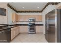 Well-equipped kitchen featuring stainless steel appliances, light wood cabinets, and tile flooring at 8250 S Hidden Trail Ct, Gold Canyon, AZ 85118