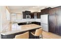 Stylish kitchen with granite countertops, dark wood cabinetry, and stainless steel appliances, and bar seating at 8562 W Windsor Blvd, Glendale, AZ 85305