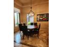 Elegant dining room with a modern chandelier, stylish decor, and large windows offering a pleasant view at 8928 E Wethersfield Rd, Scottsdale, AZ 85260