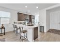 Bright kitchen featuring a spacious quartz countertop island with bar stool seating and a large stainless steel refrigerator at 9008 W Bethany Heights Dr, Glendale, AZ 85305