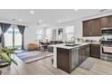 Modern, open-concept kitchen featuring stainless steel appliances, an island, and seamless flow into the living area at 9008 W Bethany Heights Dr, Glendale, AZ 85305