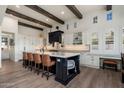 Spacious kitchen island featuring seating, custom cabinetry, white countertops, and views of the surrounding living spaces at 9565 E Mountain Spring Rd, Scottsdale, AZ 85255