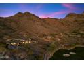 Luxury home nestled near mountain with golf course and desert landscaping under a colorful sky at 9820 E Thompson Peak Pkwy # 629, Scottsdale, AZ 85255