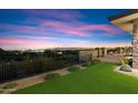 Outdoor patio with artificial turf and railing showcases stunning city views at twilight at 9820 E Thompson Peak Pkwy # 629, Scottsdale, AZ 85255