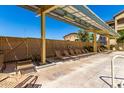 Community pool with lounge chairs under a shaded canopy, providing a relaxing outdoor space at 10136 E Southern Ave # 3065, Mesa, AZ 85209
