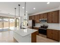 Modern kitchen featuring stainless steel appliances, a central island, and sliding glass doors to the backyard at 11627 W Beck Ave, Youngtown, AZ 85363