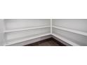 Walk-in pantry with multiple levels of shelving for ample storage and wood look tile floors at 11627 W Beck Ave, Youngtown, AZ 85363