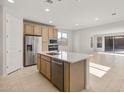 Open-concept kitchen boasts stainless steel appliances, an island with a sink, and plenty of cabinet space at 13548 W Copperleaf Ln, Peoria, AZ 85383