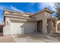 Exterior view of home featuring a two-car garage, front porch, and desert landscaping at 17254 W Marshall Ln, Surprise, AZ 85388