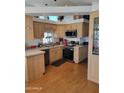 Bright kitchen with stainless steel appliances, light wood cabinets, and hardwood flooring at 2260 S Seminole Dr, Apache Junction, AZ 85119