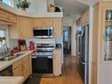 Well-lit kitchen featuring stainless steel appliances, light wood cabinets, and sleek countertops at 2260 S Seminole Dr, Apache Junction, AZ 85119