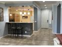 Kitchen breakfast bar with pendant lighting and tile flooring leading to the front entrance at 22988 W Twilight Trl, Buckeye, AZ 85326